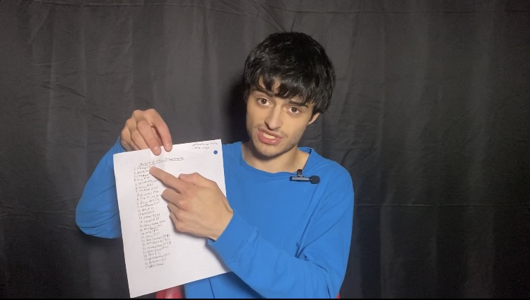 Matthew Luna holding a time tracking paper while sitting in a chair